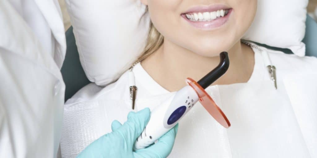 Laser dentistry equipment. Female patient smiling.