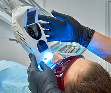 Teeth whitening blue light procedure on a patient.