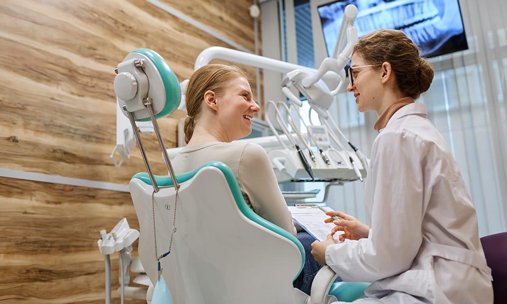Dentist doing dental checkup with a smiling patient for Teeth-in-an-hour.
