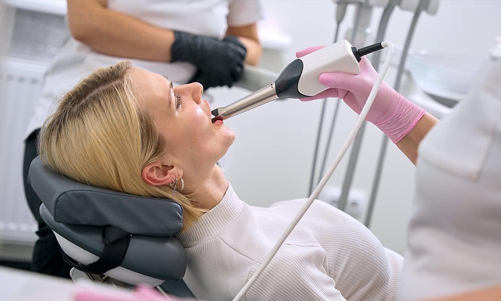 Dental professional using Trios Impression Scanner on patient.