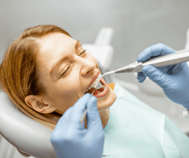 Woman during a dental check-up for a periodontal treatment at the office.