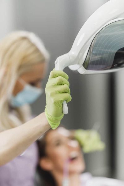 Hygienist clasping a machine handle while examining patient.